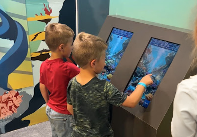 Children playing Building Life, an interactive DNA learning game developed by 303 Software for Butterfly Pavilion.