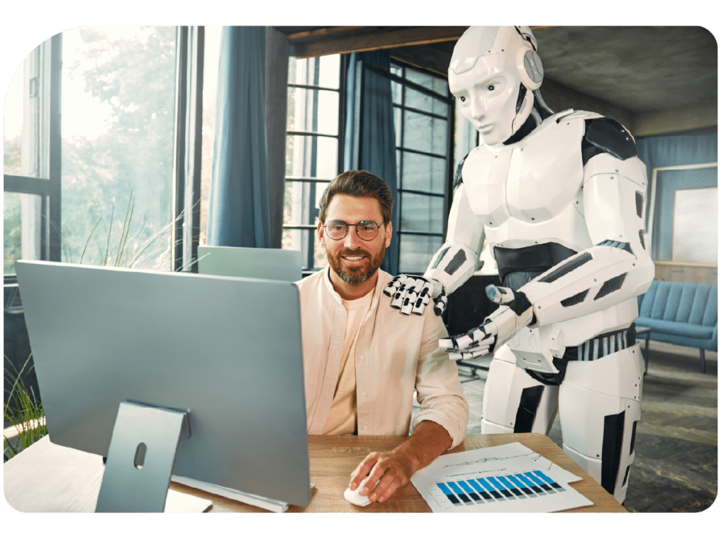 Smiling man working on a computer with a humanoid AI robot assisting him, illustrating vibe coding and AI-powered app development.